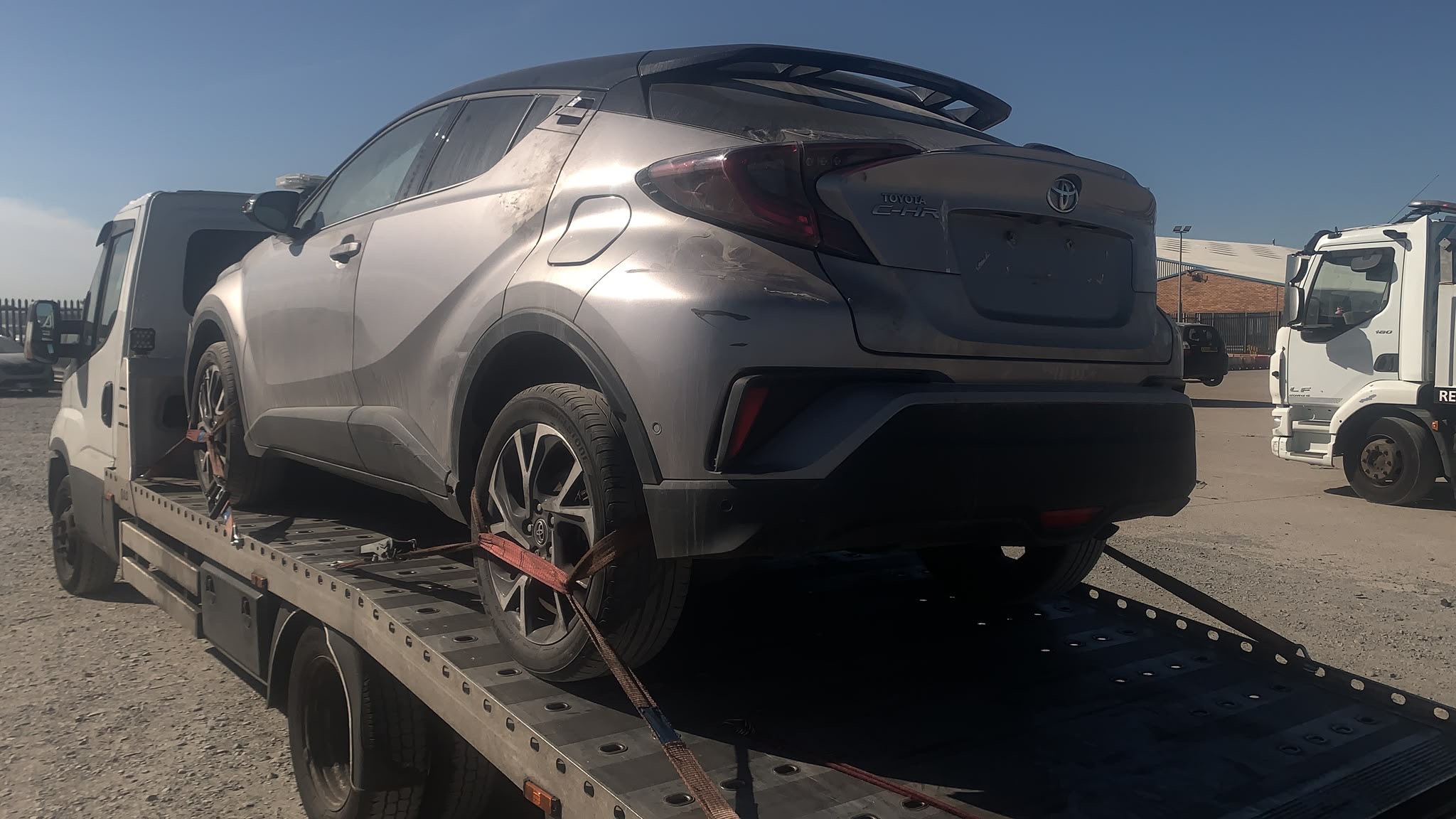 Damaged Toyota crossover secured on a recovery truck