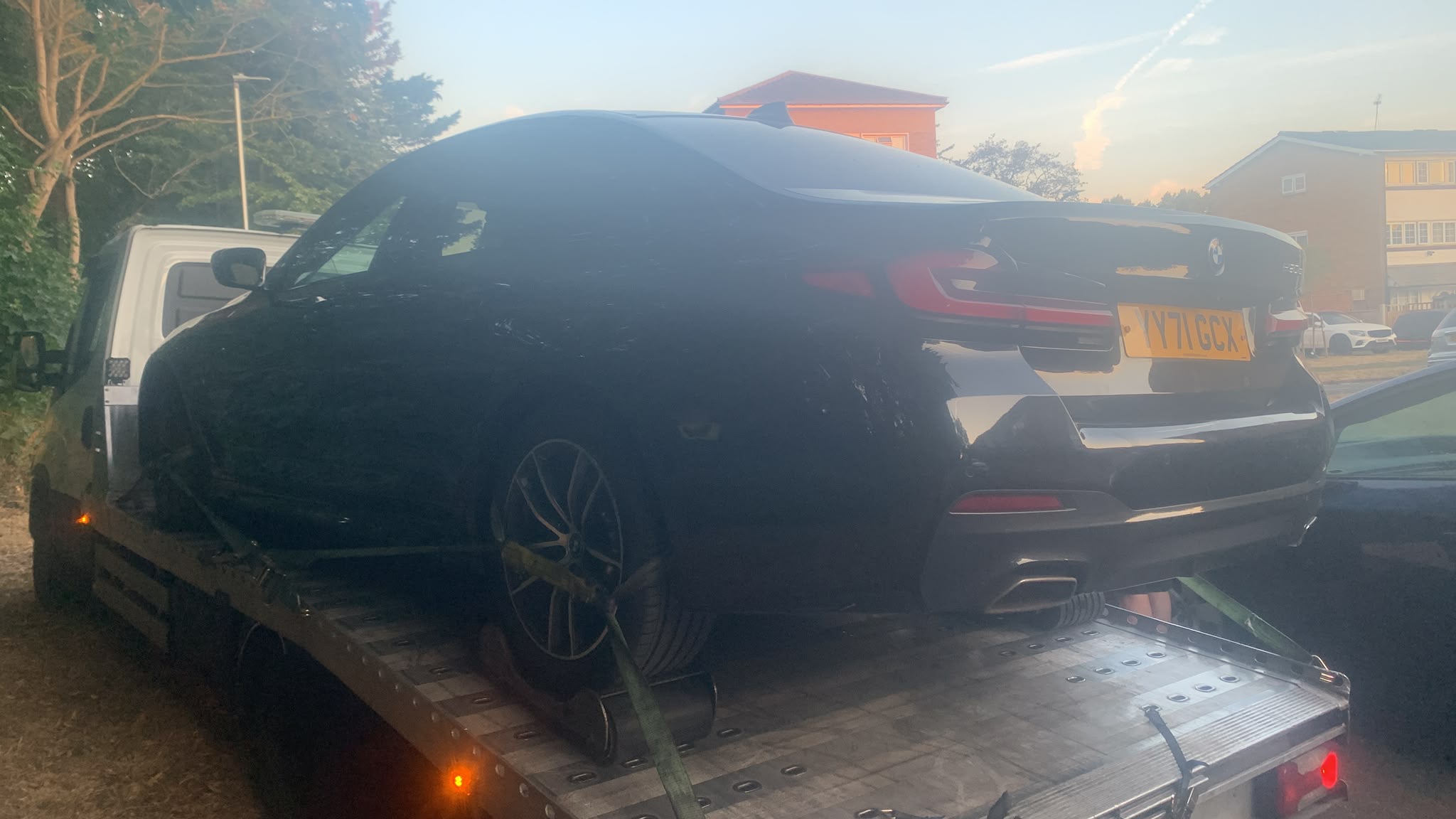 Black BMW prestige car secured on a flatbed truck